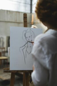 Artist sketching a portrait on canvas in an art studio, showcasing creativity and technique.